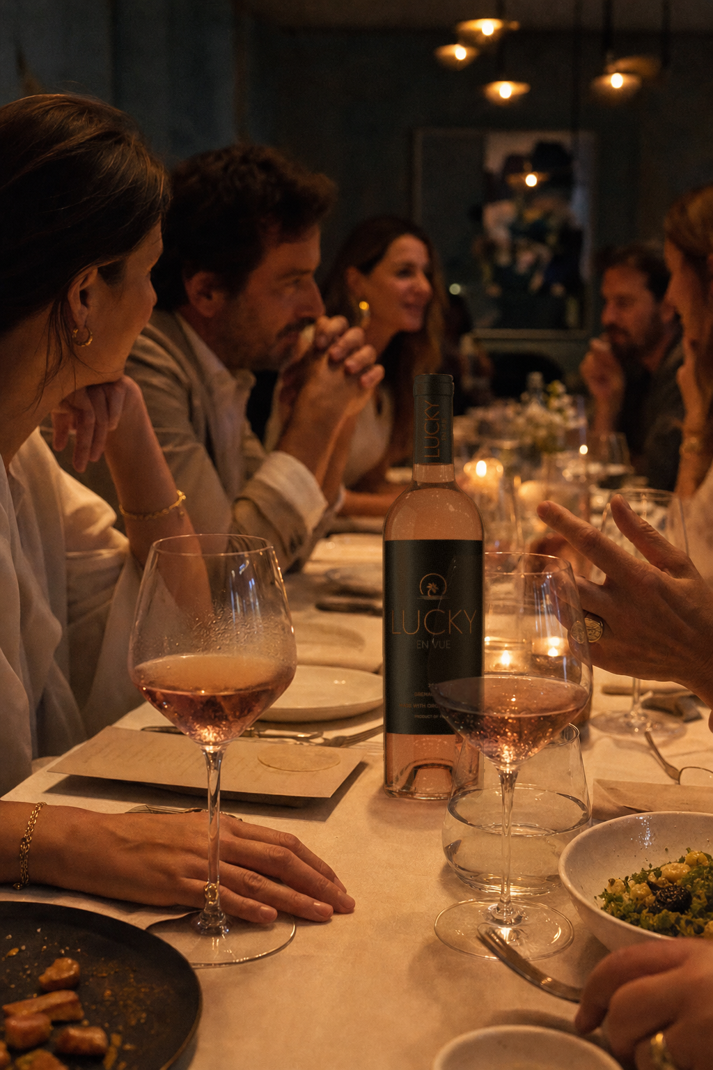 Friends at a candlelit dinner party, glasses of rosé on the table.